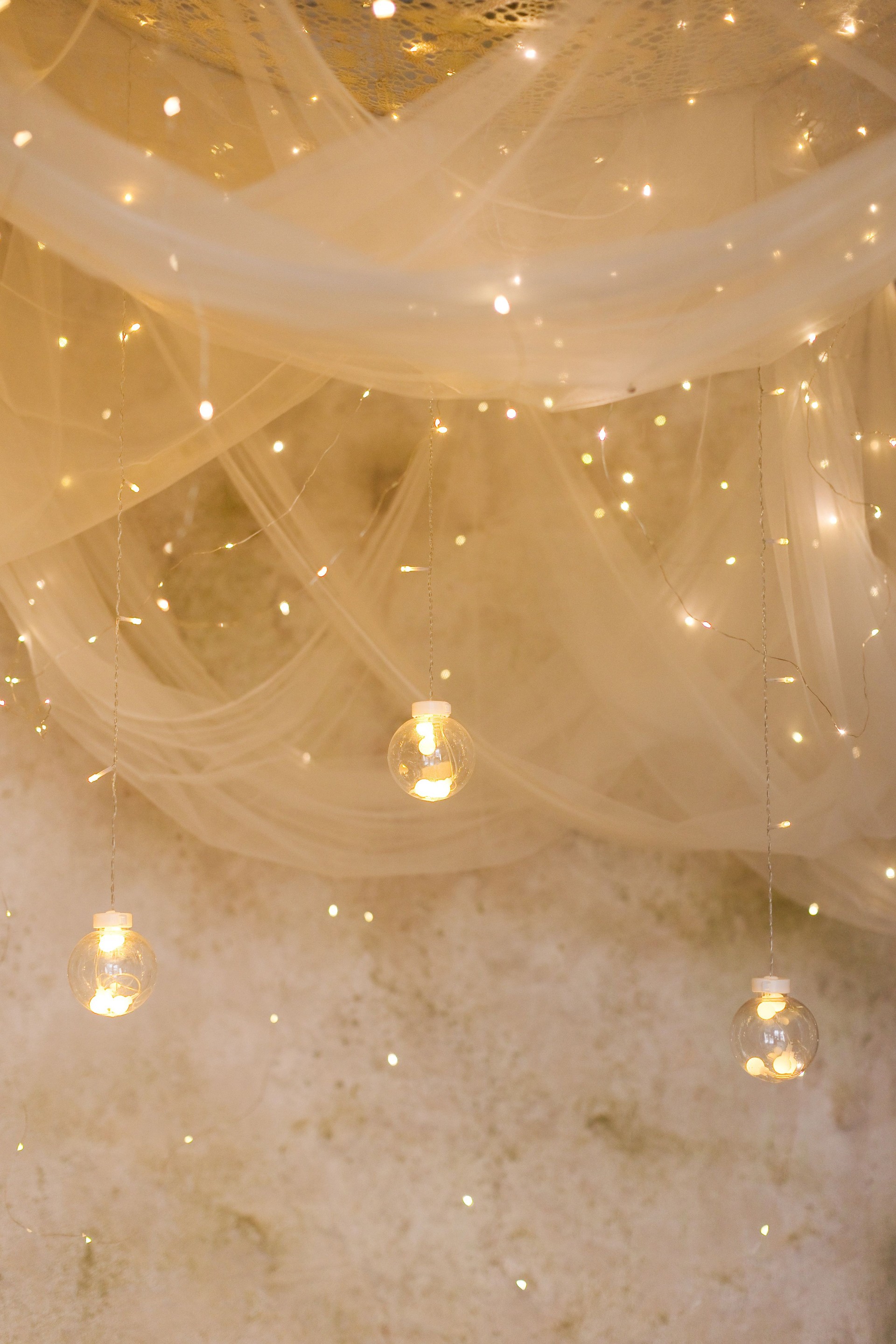 Hanging candles and garland under canopy